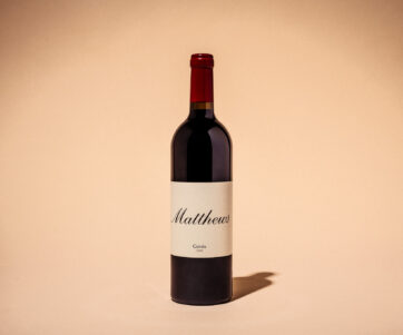 Studio shot of a 2018 Cuvee bottle with a creme background