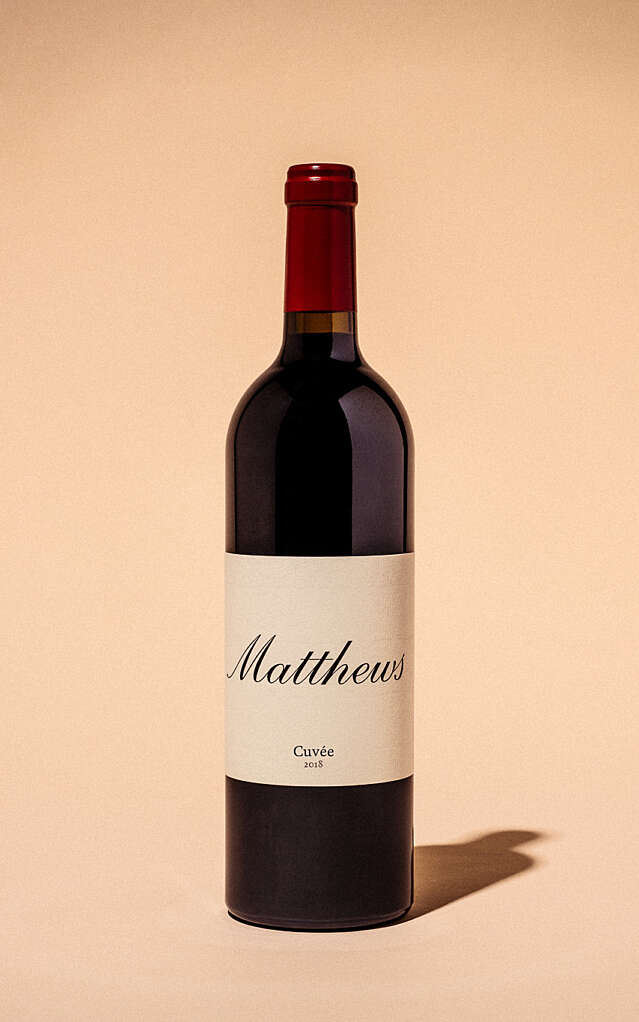 Studio shot of a 2018 Cuvee bottle with a creme background