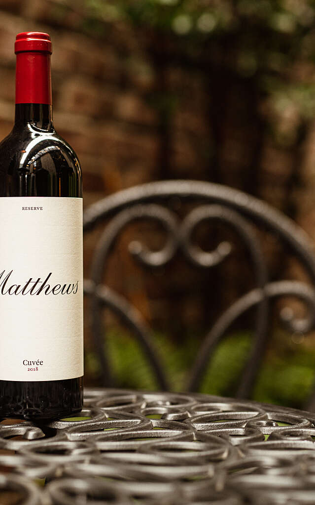 Close up of 2018 Reserve Cuvee bottle placed on outdoor iron table